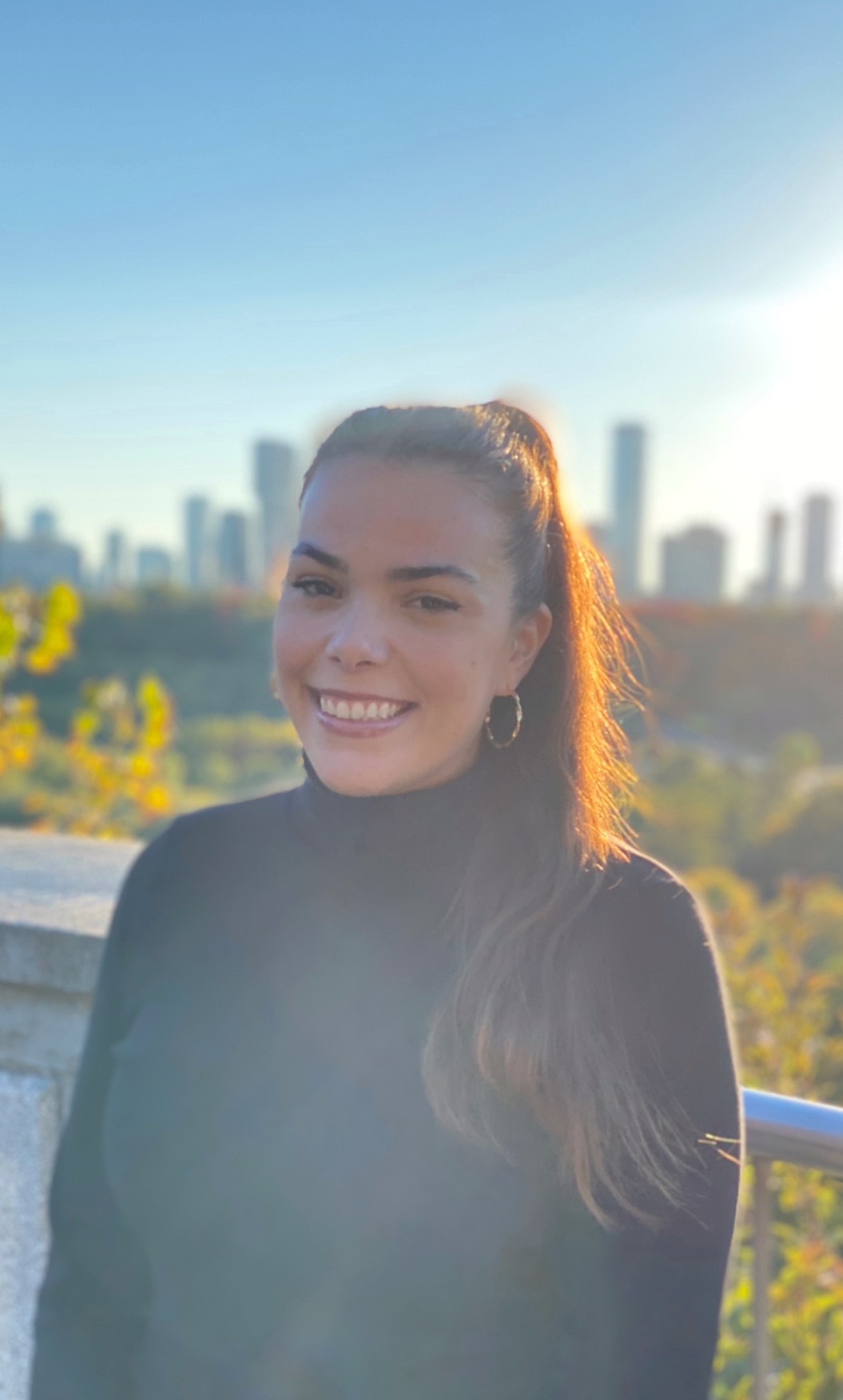 A portrait of a woman smiling, big city in the background